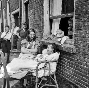 823291 Afbeelding van een groep kinderen voor het pand Achterstraat 29 te Utrecht; rechts in het raam Wies Bronius en ...
